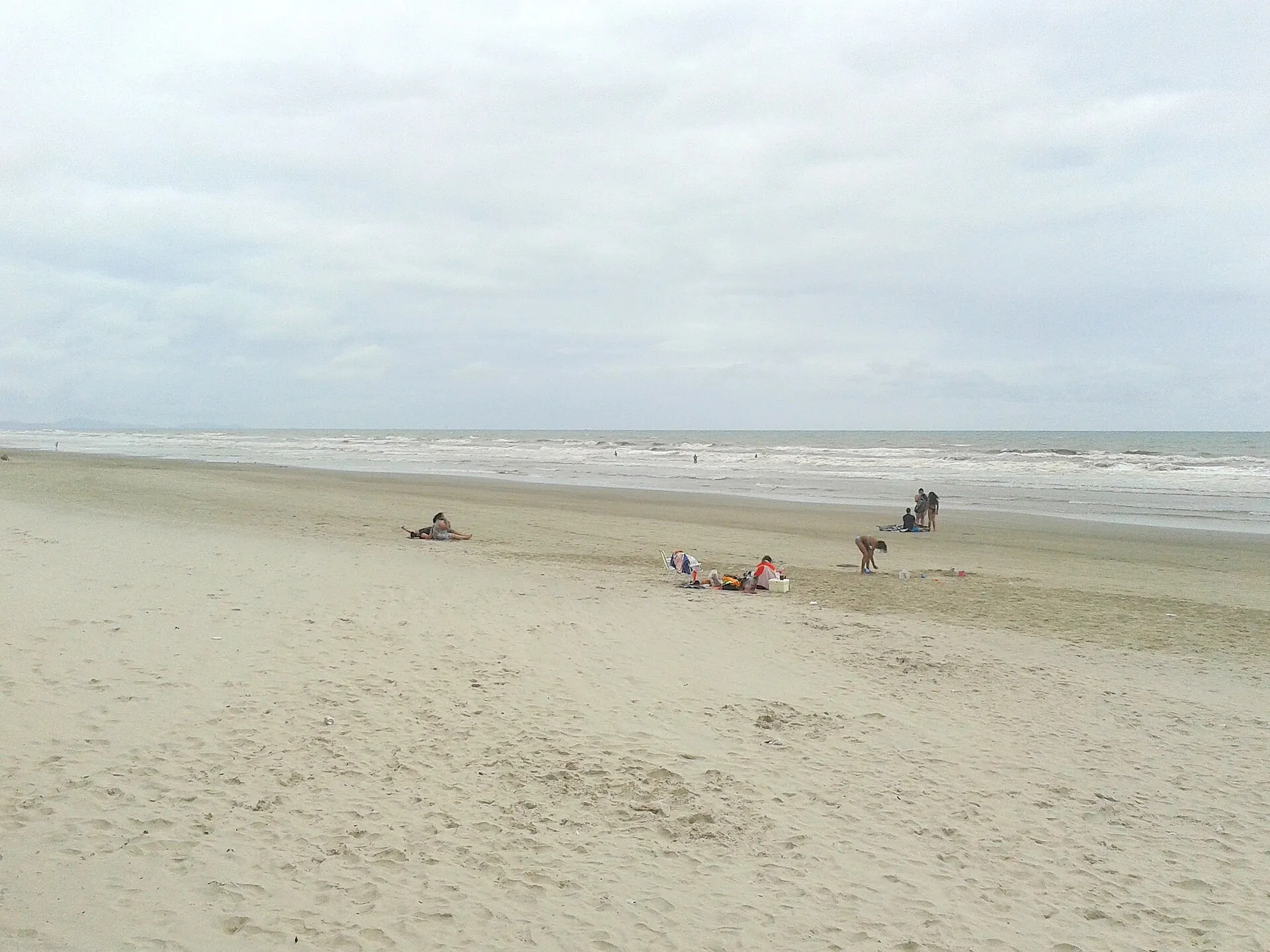 Praia do Centro, em Mongaguá, com a faixa larga de areia e o mar